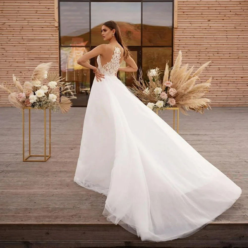 Get ready to say "I do" in style with Robe Claude! This boho wedding dress features a unique cape design, A-line silhouette, and intricate lace and tulle detailing. The high neck and illusion princess bride design will make you feel like royalty on your special day.