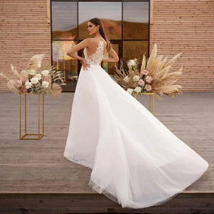 Get ready to say "I do" in style with Robe Claude! This boho wedding dress features a unique cape design, A-line silhouette, and intricate lace and tulle detailing. The high neck and illusion princess bride design will make you feel like royalty on your special day.