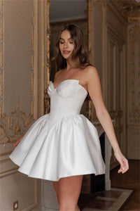 Fall in love with the elegant Ella mini dress, perfect for any bride-to-be. Made with luxurious white satin fabric and designed with a strapless, sleeveless heart-shaped neckline, this dress exudes sophistication and charm. Its short length adds a modern touch, making it the ideal dress for any wedding occasion.