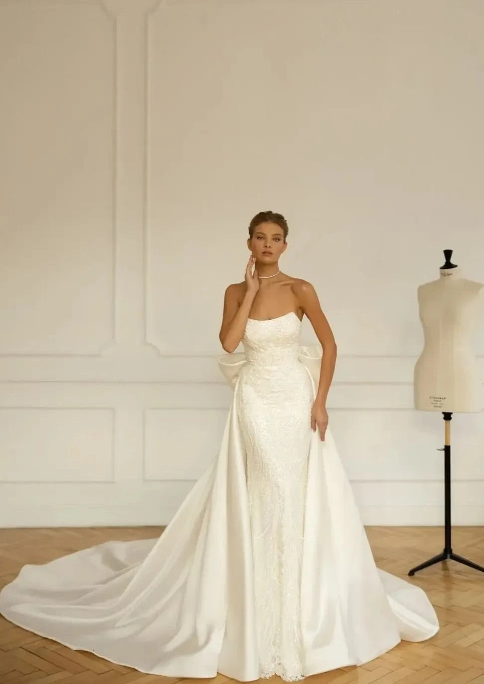 The Robe Natassia is perfect for the bride who likes options! With a detachable train, this sleeveless sheath bridal gown can be easily transformed for a more versatile look. The neckline adds an elegant touch, making it a great choice for any wedding. (Vow to wow!)