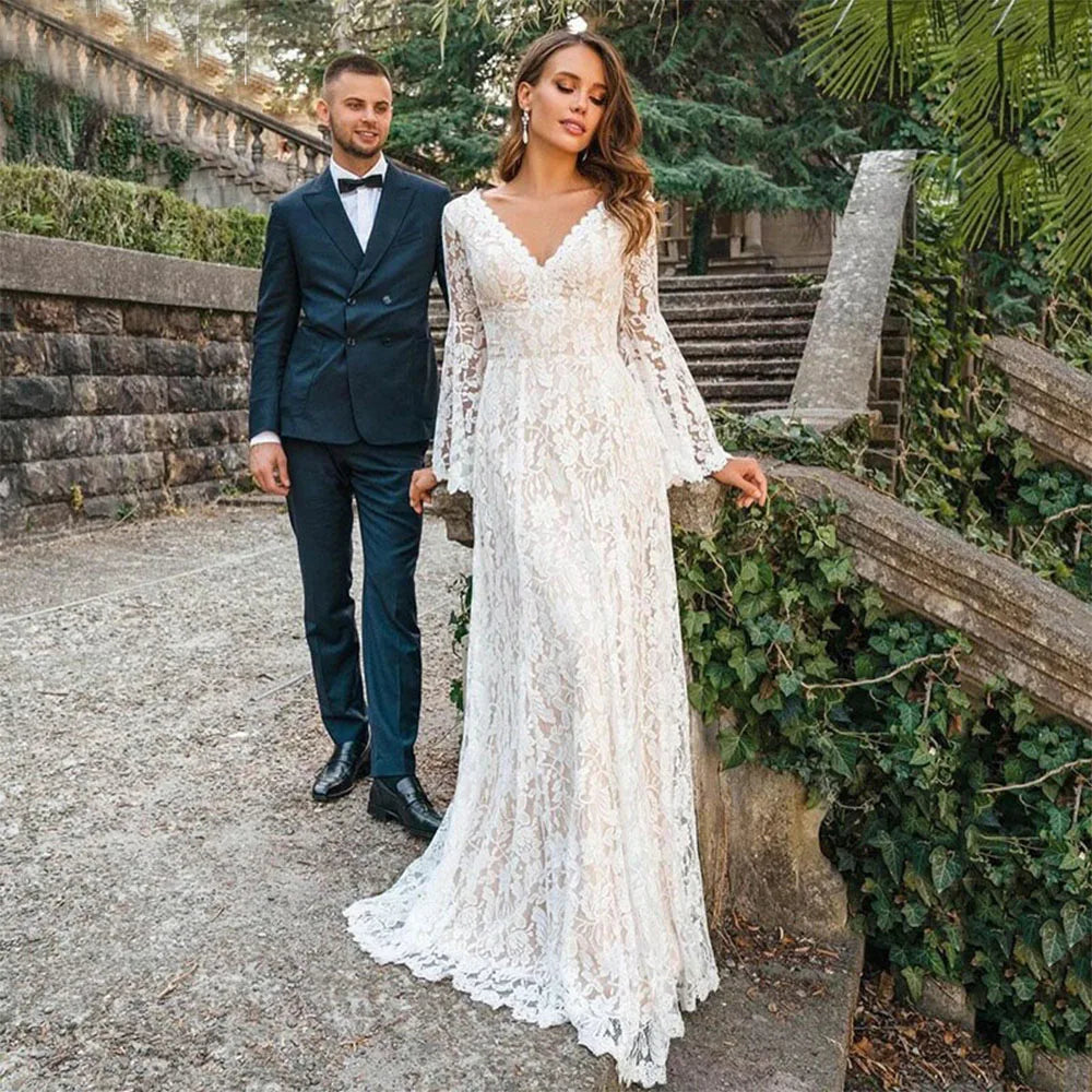 Indulge in luxury with our Dress Arabelle. Showcasing delicate scalloped lace and a plunging v-neck, this wedding dress is customizable with long bell sleeves and tassled ties at the back for a bohemian touch. Cutouts add a modern twist to this timeless piece. Perfect for the sophisticated and fashionable bride.
