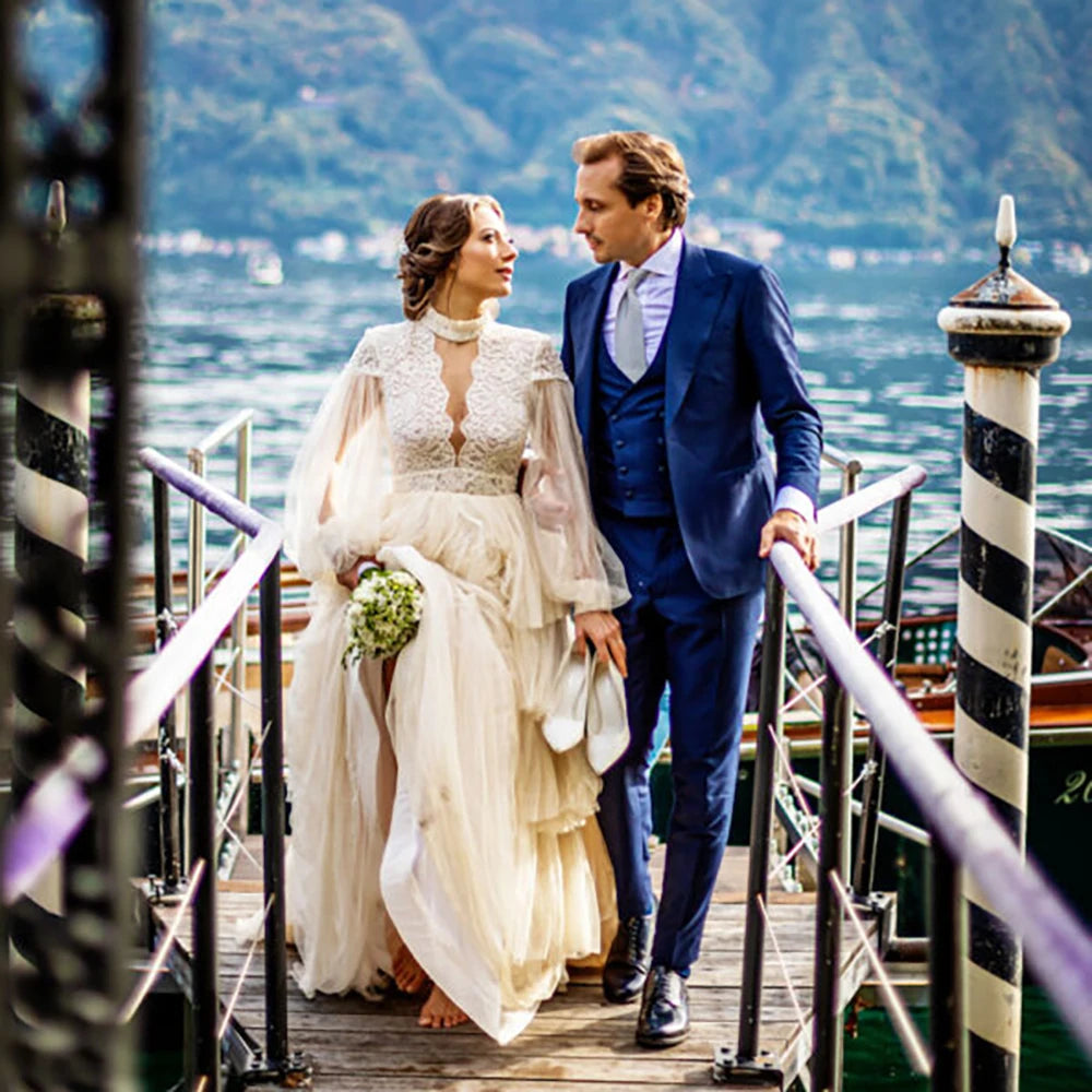 Indulge in sophistication and elegance with our Robe Tali. Featuring long Bishop sleeves, a high neck, and a vintage rustic design, this ball gown is the epitome of luxury. Delicate lace detailing, an open back, and a deep V keyhole add to the allure, making you the center of attention on your special day.