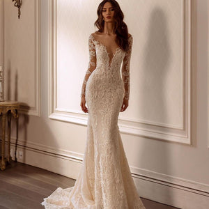Look and feel like a beautiful bride on your special day with the Robe Juliet. This gorgeous white lace wedding gown features long sleeves and intricate embroidery, creating a stunning bridal look. Perfect for a romantic and timeless wedding.