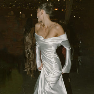 Introducing the Robe Rochelle - the perfect blend of sleek and elegant. With its long sleeves and dropped off shoulder design, this satin wedding dress exudes a simple yet glamorous vibe. Custom made to ensure a glossy finish, this dress is bound to make you shine on your special day.