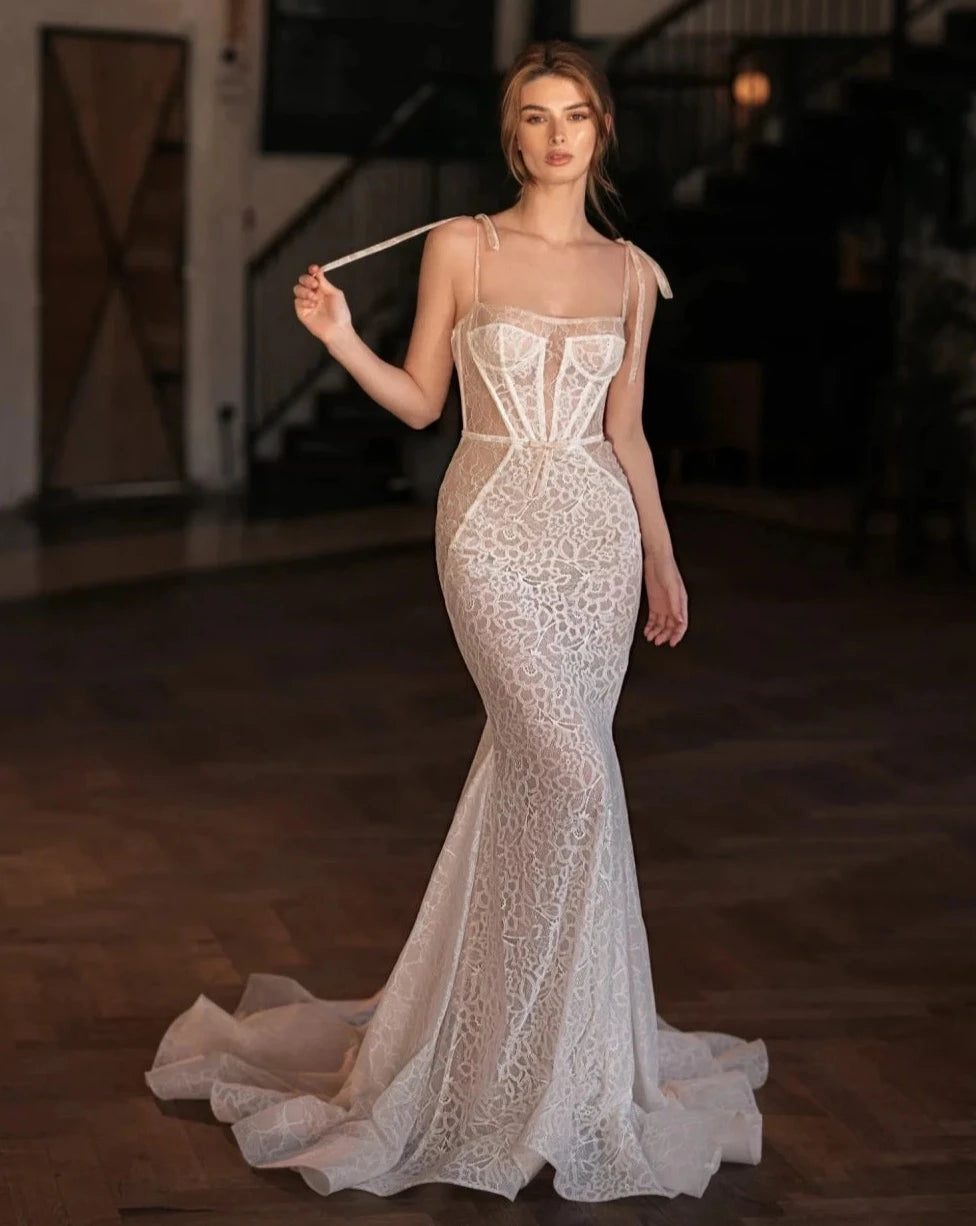 Indulge in elegance with our Robe Katarina. This classic square neck wedding dress features graceful spaghetti straps and delicate lace details for a modest, yet alluring look. The mermaid silhouette and long length make it perfect for a sophisticated bride. Exclusively designed for you, our Robe De Mariée is a must-have for your special day.