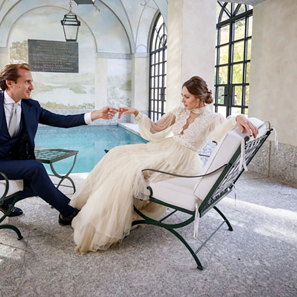Indulge in sophistication and elegance with our Robe Tali. Featuring long Bishop sleeves, a high neck, and a vintage rustic design, this ball gown is the epitome of luxury. Delicate lace detailing, an open back, and a deep V keyhole add to the allure, making you the center of attention on your special day.