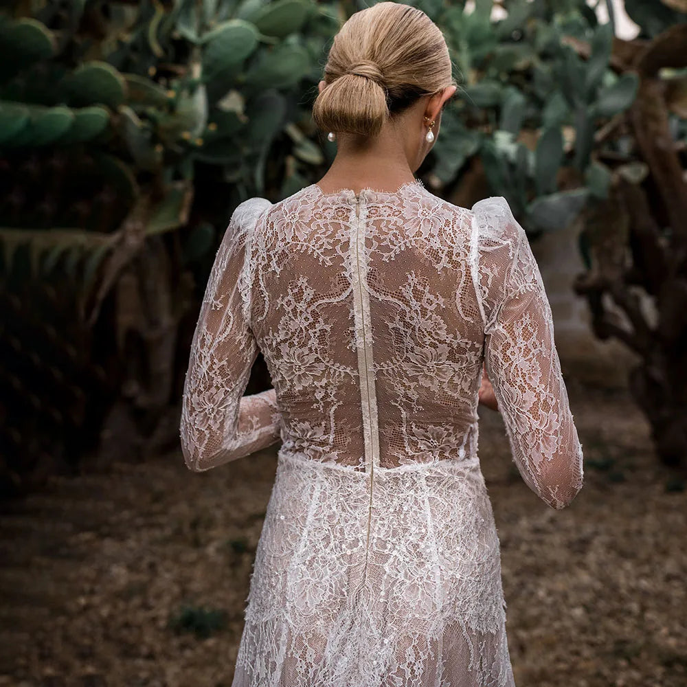 Capture a sophisticated look for your special day with the Robe Esme. Crafted in sheer lace, this plus size A line wedding gown features deep v neckline, long sleeves and boho maxi hipple design for a rustic yet luxe look. Perfect for photography, the dress is custom made to ensure a perfect fit. Create a timeless bridal look with Robe Esme.