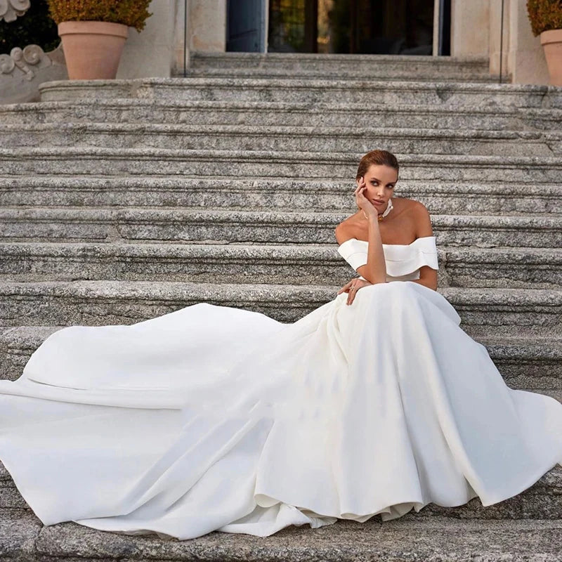 This stunning off-the-shoulder mermaid wedding dress exudes elegance and sexiness. With its flattering silhouette and mopping design, it's perfect for any bride who wants to make a statement on her special day. Make your wedding unforgettable with Dress Amelia!