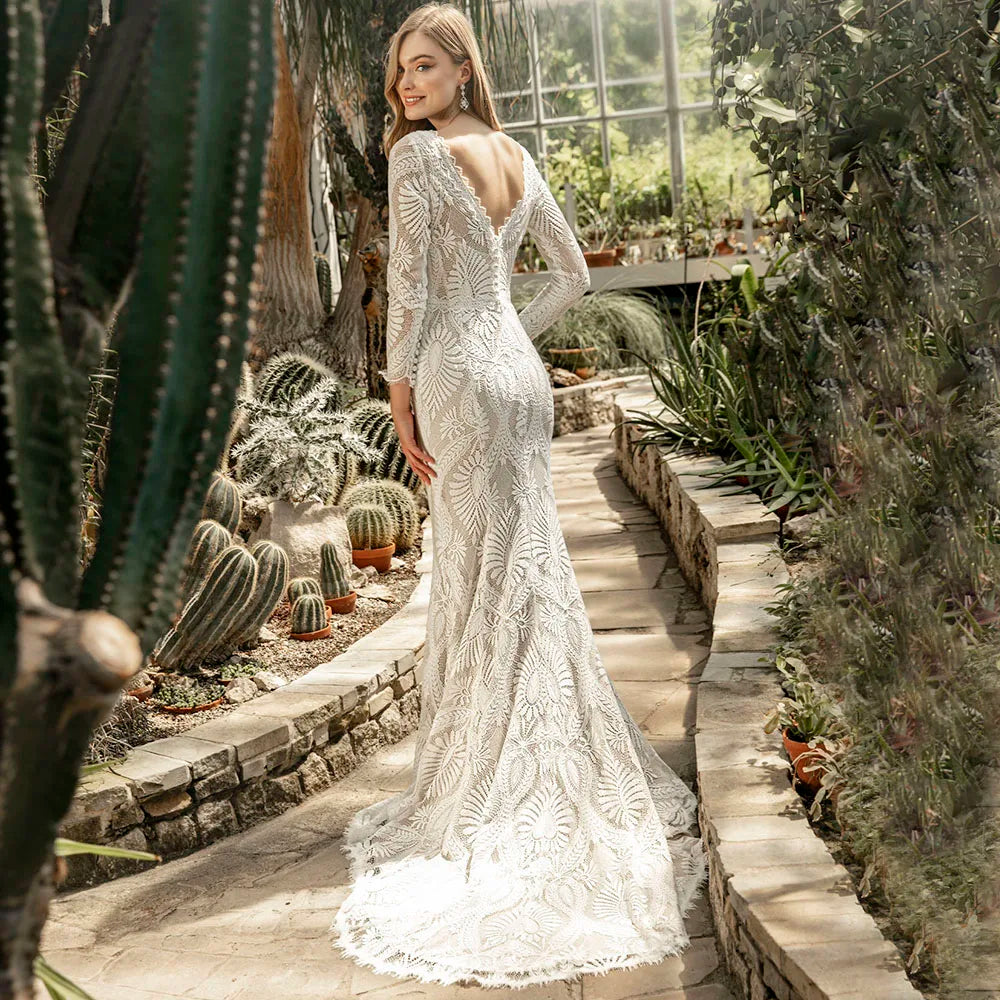 Unleash your inner bohemian goddess in our elegant Robe Mauva. The mermaid cut and lace detailing accentuate your curves, while the cutout V neck adds a touch of allure. Perfect for a rustic beach wedding, this dress is customizable for the perfect bodycon fit. The long sleeves and brush train buttons complete this luxurious bridal look.