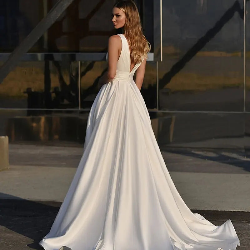 Get ready to stun in the Robe Zenna! This elegant wedding dress features a deep V-neck and backless design, perfect for those who want to make a statement. The spaghetti straps add a touch of delicacy, while the side slit and A-line cut flatter your figure. Feel like a goddess on your special day.