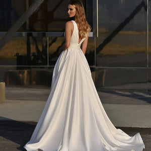 Get ready to stun in the Robe Zenna! This elegant wedding dress features a deep V-neck and backless design, perfect for those who want to make a statement. The spaghetti straps add a touch of delicacy, while the side slit and A-line cut flatter your figure. Feel like a goddess on your special day.