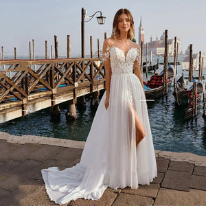 Robe Lilou is a stunning sweetheart A-Line wedding dress featuring a white off the shoulder backless design with exquisite lace applique and a side split. Crafted from the finest chiffon material, it makes a perfect choice for brides who want maximum comfort and elegance.
