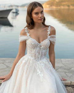 Captivate the room in this exquisite Robe Gigi. Crafted with luxurious lace appliques, a sweetheart neckline, and a figure-defining corset bodice, this romantic princess wedding gown looks as if it were poured from a Dutch Masters painting. Let the delicate tulle skirt and spaghetti straps drape gracefully, for a look that is both elegant and timeless.