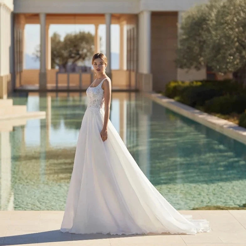 Feel like a modern princess in our Dress Jossette! With a square neck, delicate spaghetti straps, and a stunning open back, this ivory wedding dress is sure to turn heads. Made with high-quality tulle, this custom piece is perfect for your special day. And with a sweeping train, you'll feel like royalty as you walk down the aisle. Order now and make your dream wedding a reality!