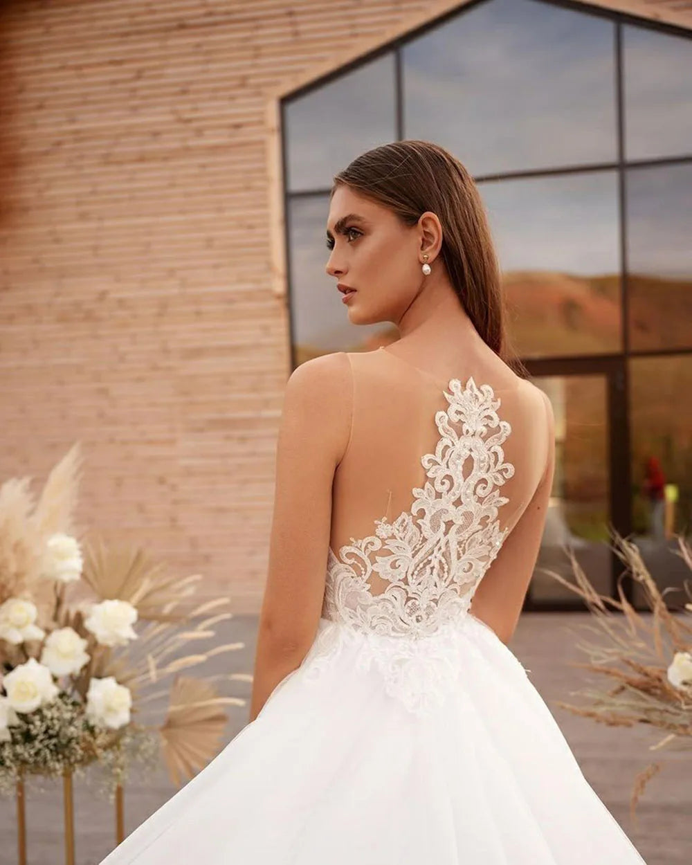 Get ready to say "I do" in style with Robe Claude! This boho wedding dress features a unique cape design, A-line silhouette, and intricate lace and tulle detailing. The high neck and illusion princess bride design will make you feel like royalty on your special day.
