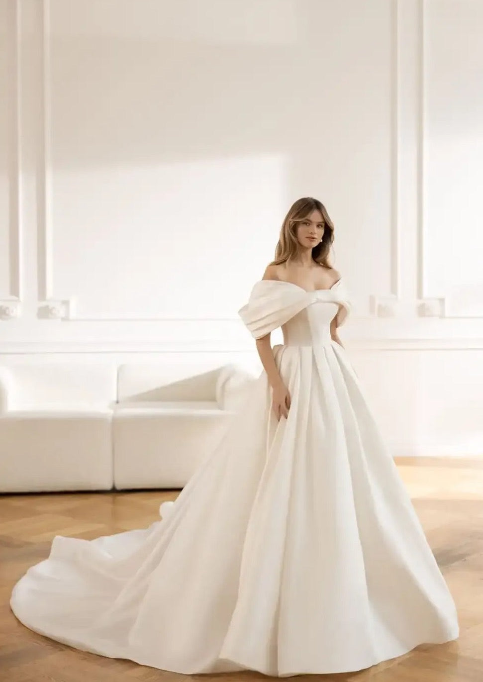 Introducing the Robe Elia - the perfect addition to your special day! This wedding dress features an elegant sweetheart neckline, delicate bow accents, and a romantic off the shoulder design. The A-line silhouette flatters every figure, while the ruched bodice adds a touch of sophistication.