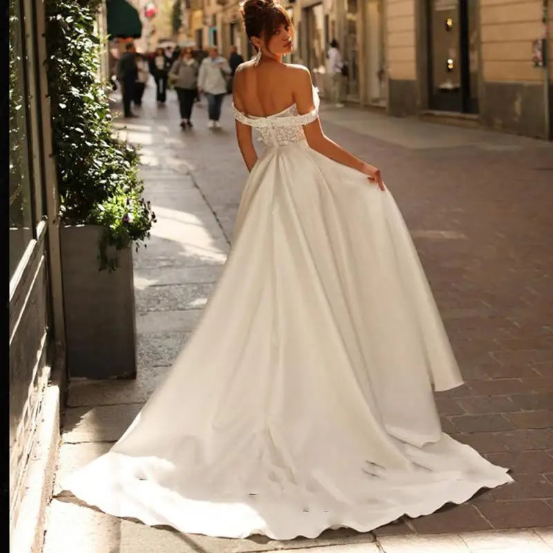 Introducing Dress Eleanor, the ultimate bohemian V-neck wedding dress. With its off the shoulder design, high side slit, and backless style, this dress exudes sexy sophistication. The intricate lace applique and A-line silhouette add a touch of femininity to complete the look. Perfect for the free-spirited bride looking to make a statement on her special day.