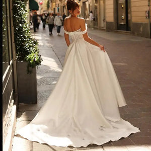 Introducing Dress Eleanor, the ultimate bohemian V-neck wedding dress. With its off the shoulder design, high side slit, and backless style, this dress exudes sexy sophistication. The intricate lace applique and A-line silhouette add a touch of femininity to complete the look. Perfect for the free-spirited bride looking to make a statement on her special day.