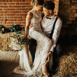 Unleash your inner bride in our Robe Tali - the perfect combination of elegance and rustic charm. Featuring a fringed sheath lace design, this custom-made wedding dress is sure to turn heads. The deep v-neck and halter style add a touch of romance, while the fitted silhouette flatters all sizes. Say "I do" in style with our Robe Tali.
