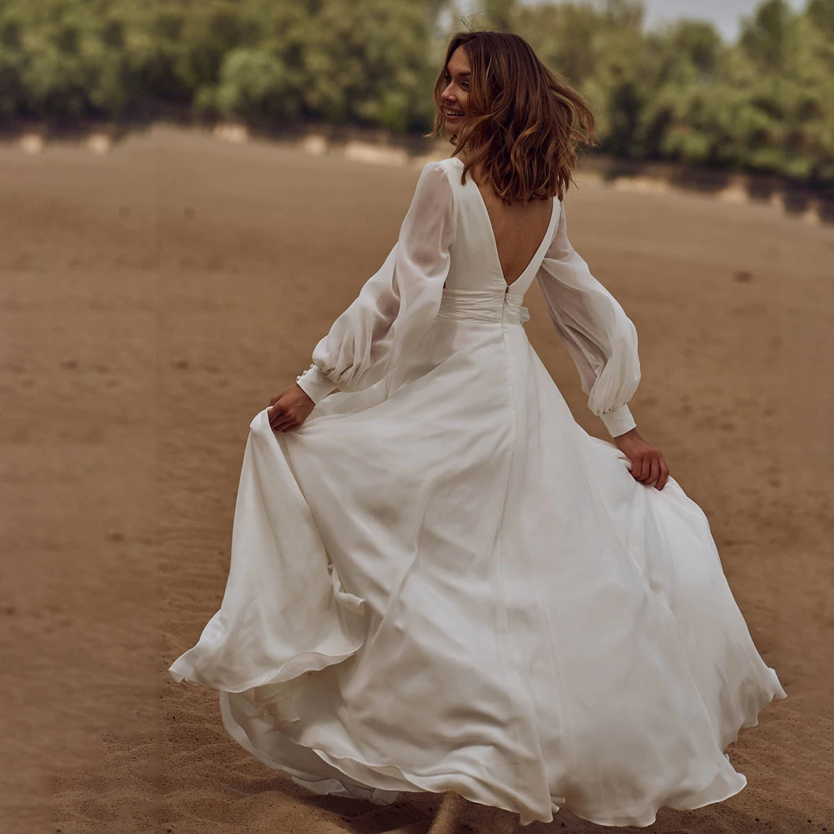 Look effortlessly elegant on your special day with our Dress Sidnea. This maxi floor length chiffon wedding dress features long bishop sleeves, a v-neckline, and a backless design for a touch of sophistication. The self-tie sash adds a feminine silhouette while the high cut showcases your figure. Say "I do" in style with this stunning dress.