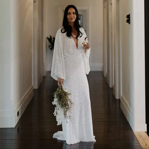 Robe Severine is an exquisite wedding dress tailored to perfection. Richly detailed with lustrious sequined V-neck and long batwing sleeves, it is tailored for an unforgettable bridal gown experience. Its custom-made overweight sizing ensures a comfortable fit and its crystals add a graceful touch to this elegant gown.