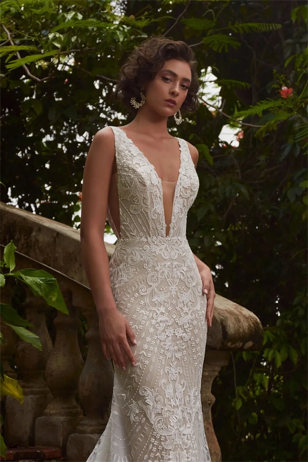 Elevate your special day in the Robe Jacqueline. This exquisite mermaid-style dress is crafted with V-neck and brush floor-length silhouette. Featuring an open back and handmade flower lace accents, this wedding dress is sure to make an unforgettable impression.