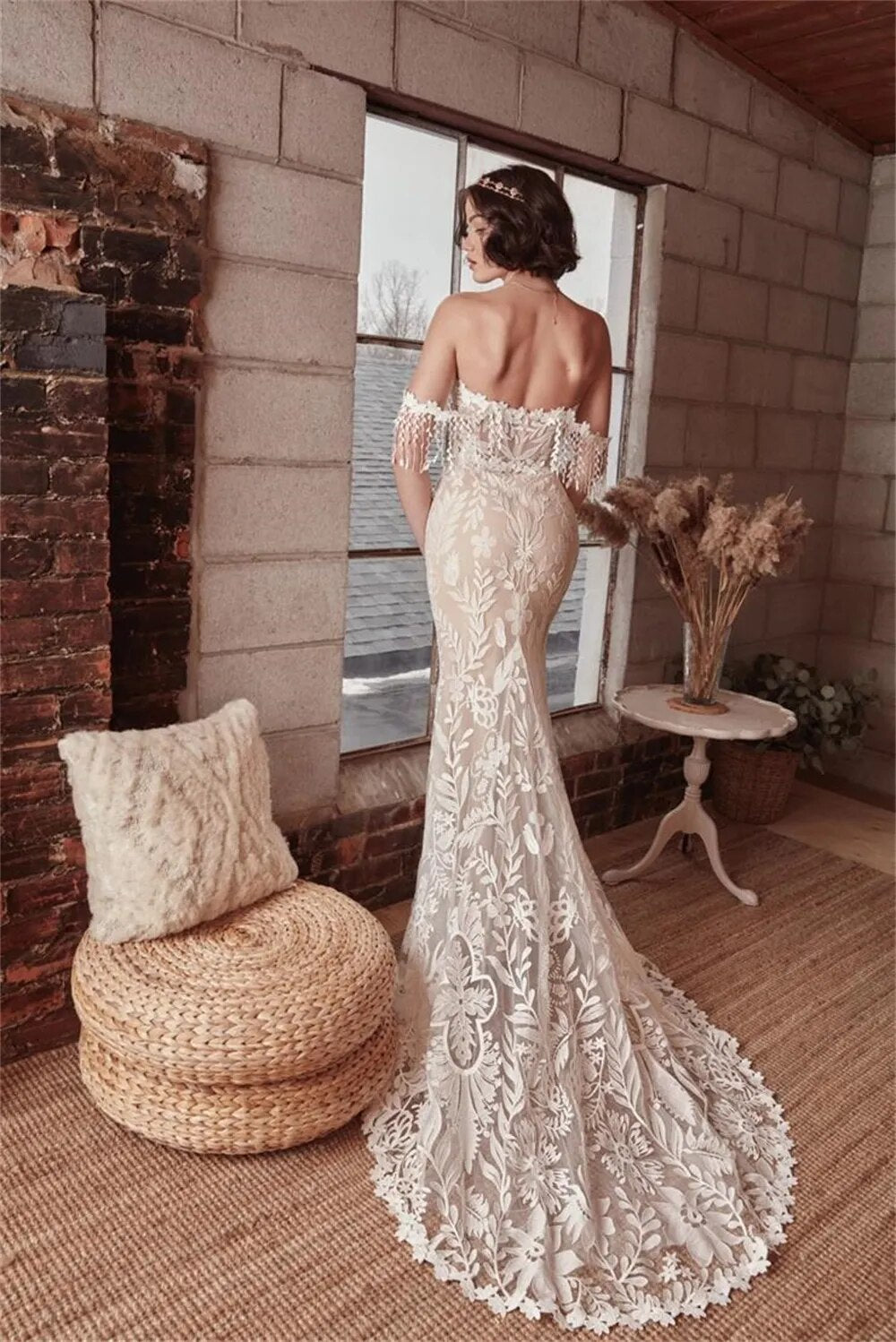 This Robe Cosette wedding dress is the perfect mix of sweet and sexy. The sheath silhouette and delicate lace fabric are complemented by an off-the-shoulder neckline and sweep train. Highly flattering and comfortable, this bridal gown is perfect for a church or civil wedding.