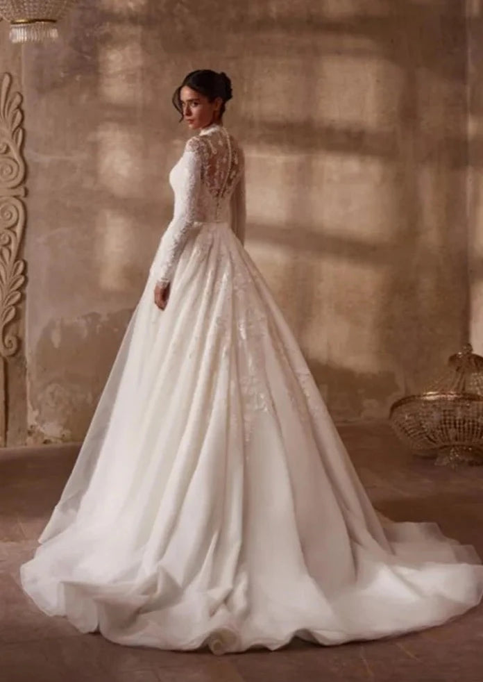 Indulge in timeless elegance with the Robe Mercer. This luxurious vintage wedding dress features intricate lace detailing, a stunning ball gown silhouette, and long sleeves for a touch of grace and sophistication. Perfect for the bride seeking a romantic and classic look on her special day.