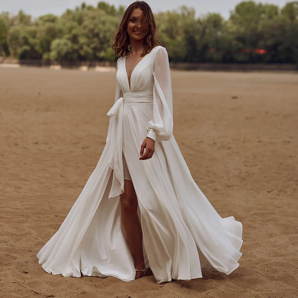 Look effortlessly elegant on your special day with our Dress Sidnea. This maxi floor length chiffon wedding dress features long bishop sleeves, a v-neckline, and a backless design for a touch of sophistication. The self-tie sash adds a feminine silhouette while the high cut showcases your figure. Say "I do" in style with this stunning dress.