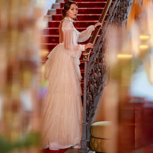 Indulge in sophistication and elegance with our Robe Tali. Featuring long Bishop sleeves, a high neck, and a vintage rustic design, this ball gown is the epitome of luxury. Delicate lace detailing, an open back, and a deep V keyhole add to the allure, making you the center of attention on your special day.