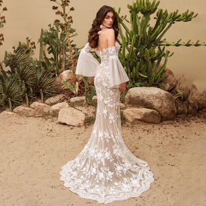 This stunning Robe Calais features mermaid silhouette, detachable chiffon bell sleeves, and intricate lace details. Perfect for a wedding dress that allows for easy customization and effortless elegance. Feel like a mermaid on your special day with this gorgeous piece.