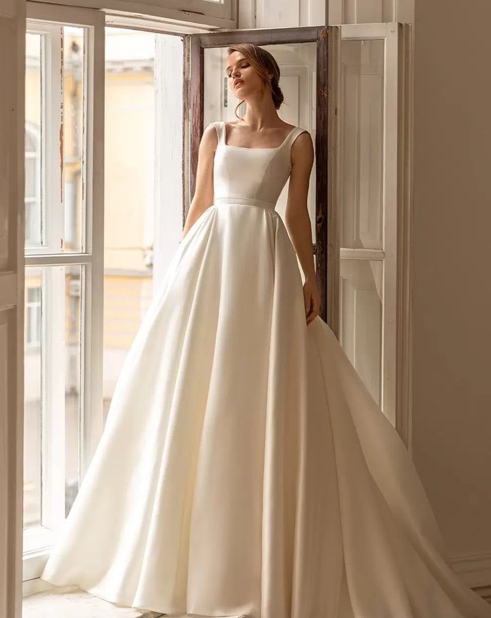 Feel like a princess on your special day with our Robe Sancia. The square neckline and full, long sleeve puff design adds elegance to the A-line silhouette. This two-piece bridal gown is perfect for any bride, ensuring a stunning and timeless look