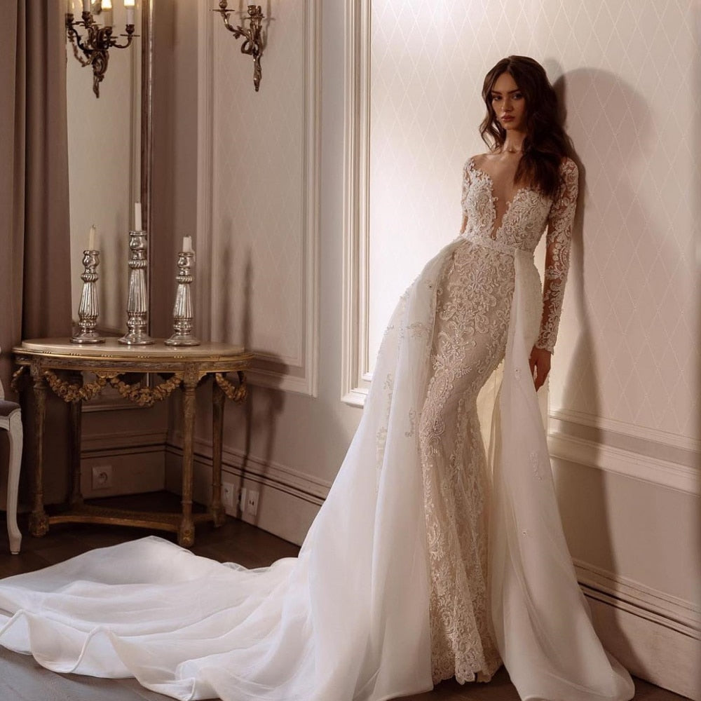 Look and feel like a beautiful bride on your special day with the Robe Juliet. This gorgeous white lace wedding gown features long sleeves and intricate embroidery, creating a stunning bridal look. Perfect for a romantic and timeless wedding.