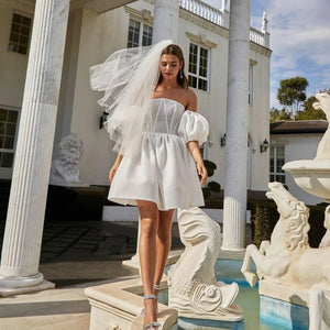 Upgrade your wedding look with Robe Liz. This mini dress features a sexy sweetheart corset and detachable puff sleeves for a customizable look. Perfect for a knee-length wedding or a night of dancing. (Wedding dress with edge. Puff sleeves add playful twist.)