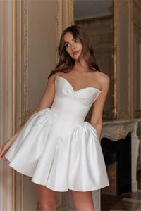 Fall in love with the elegant Ella mini dress, perfect for any bride-to-be. Made with luxurious white satin fabric and designed with a strapless, sleeveless heart-shaped neckline, this dress exudes sophistication and charm. Its short length adds a modern touch, making it the ideal dress for any wedding occasion.
