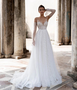 Unleash your inner boho goddess with our Robe Linnet! This stunning V-neck wedding gown features delicate dotted tulle, detachable sleeves, and ruched details for a dreamy, ethereal look. Perfect for the free-spirited bride who loves a touch of whimsy on her special day. Say 'I do' to the Robe Linnet!
