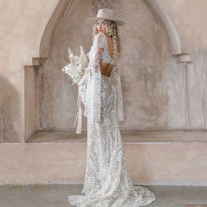 Our Robe Margaux dress is a timeless piece built for special occasions. This plus-size custom-made design features a lace square neck, long bat sleeves, backless side hollow cutouts, and a mermaid rustic bridal gown. Create a one-of-a-kind look that is perfect for your special day.