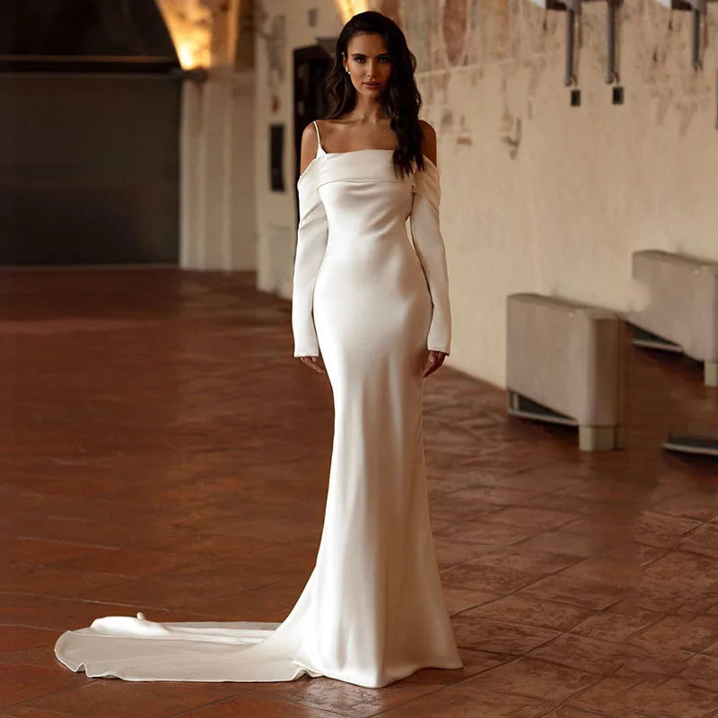 Indulge in luxury with Dress Jules - an elegant, custom-made bridal gown featuring long sleeves and a court train. This trumpet style dress is the epitome of simplicity and sophistication, perfect for a timeless and tasteful wedding. Elevate your special day with Dress Jules.