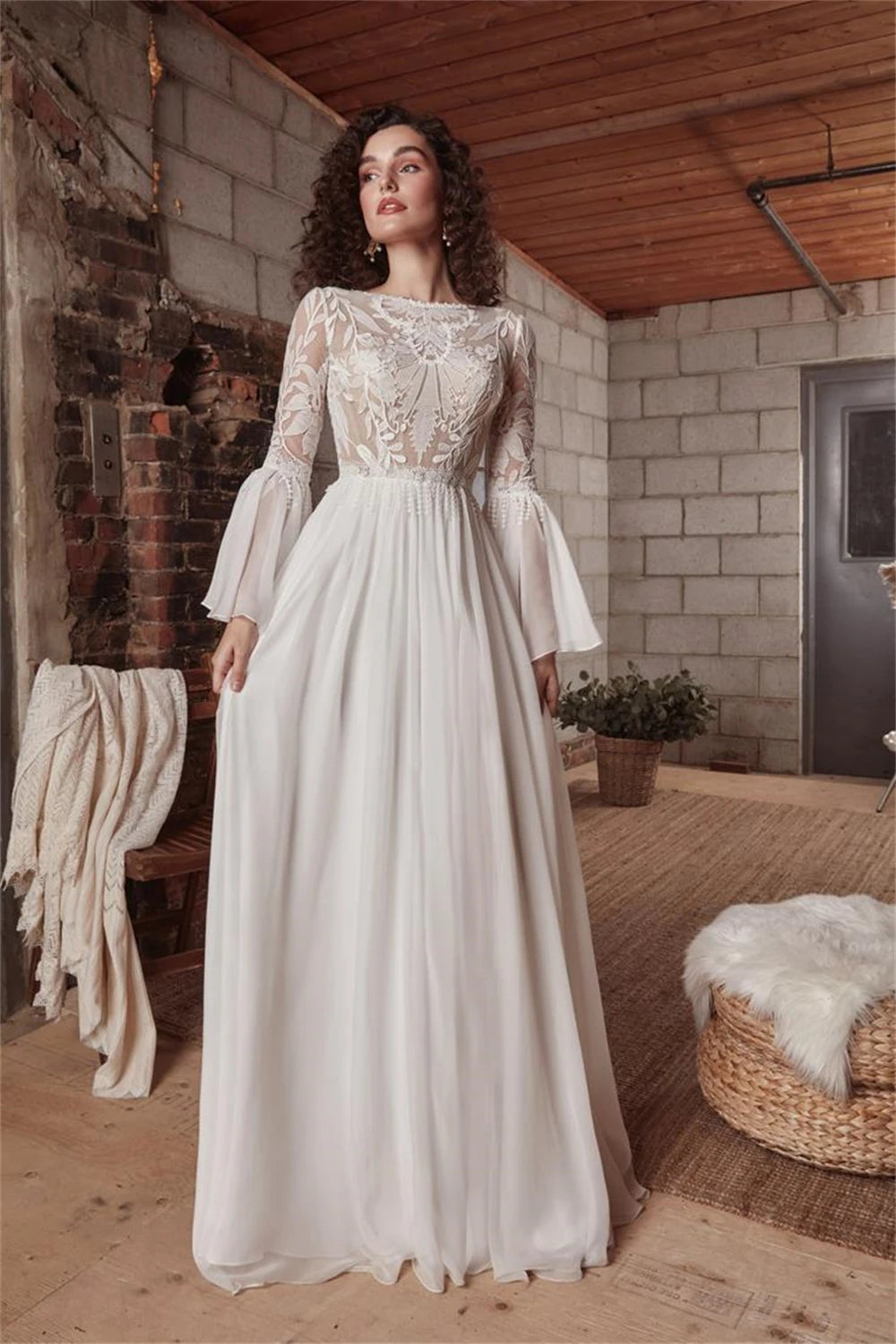 Indulge in luxury with the exquisite Dress Chamilla. This stunning wedding dress features an empire silhouette, elevated by a boat neckline and intricate lace detailing. The flowing chiffon fabric adds a touch of romance, making it the perfect choice for bridal gowns. Walk down the aisle in style and grace.