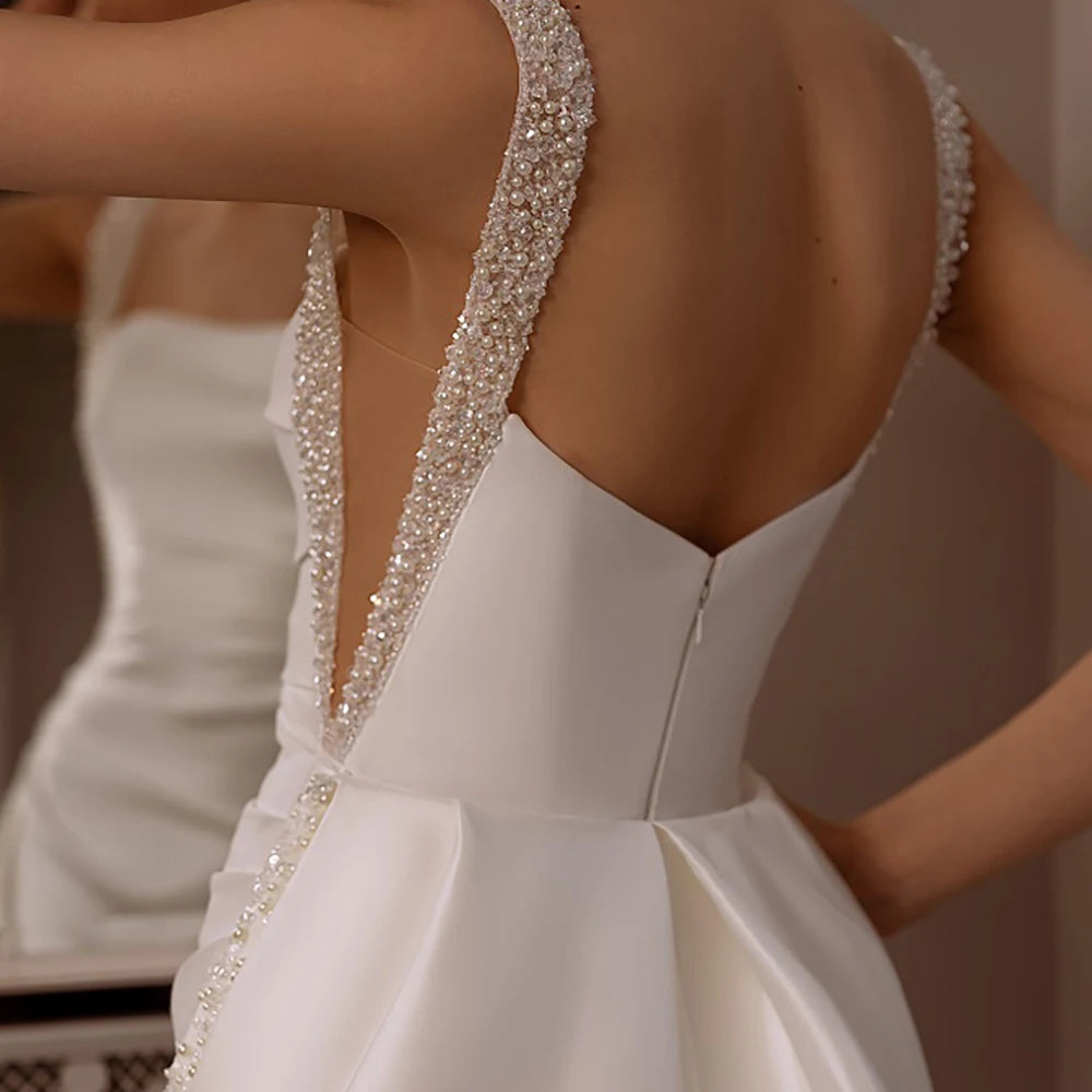 Indulge in luxury with our Robe Angeline. This bridal gown features a square neckline and elegant beading, perfectly complimented by a removable train. The custom cutouts and backless design add a touch of sophistication. Make a memorable entrance on your special day with the Robe Angeline.