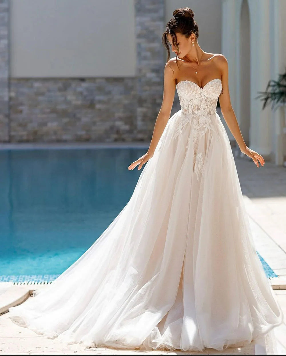 Indulge in the timeless elegance of the Robe Ariane. Adorned with intricate lace and sweet appliques, this A-Line bridal gown is fit for a princess on her special day. With a sweetheart neckline, it exudes grace and sophistication. Your fairy tale wedding awaits.