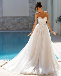 Indulge in the timeless elegance of the Robe Ariane. Adorned with intricate lace and sweet appliques, this A-Line bridal gown is fit for a princess on her special day. With a sweetheart neckline, it exudes grace and sophistication. Your fairy tale wedding awaits.