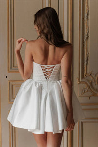 Fall in love with the elegant Ella mini dress, perfect for any bride-to-be. Made with luxurious white satin fabric and designed with a strapless, sleeveless heart-shaped neckline, this dress exudes sophistication and charm. Its short length adds a modern touch, making it the ideal dress for any wedding occasion.