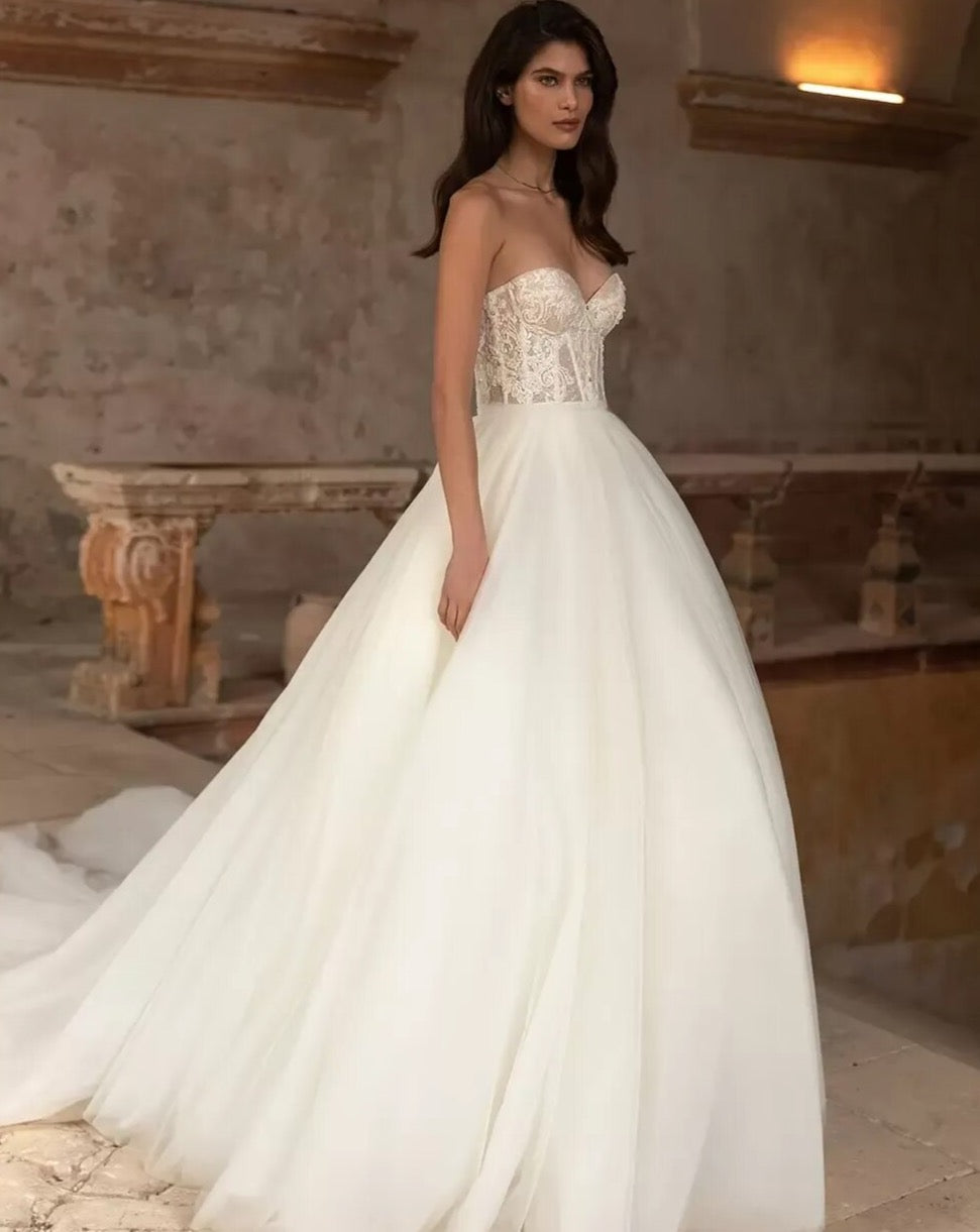 Unleash your playful and elegant side with Robe Eva! This A-line bridal gown features stunning appliques, perfect for your big day. Make a statement with this tres elegante robe, designed for the fashion-forward bride. Say oui to style!