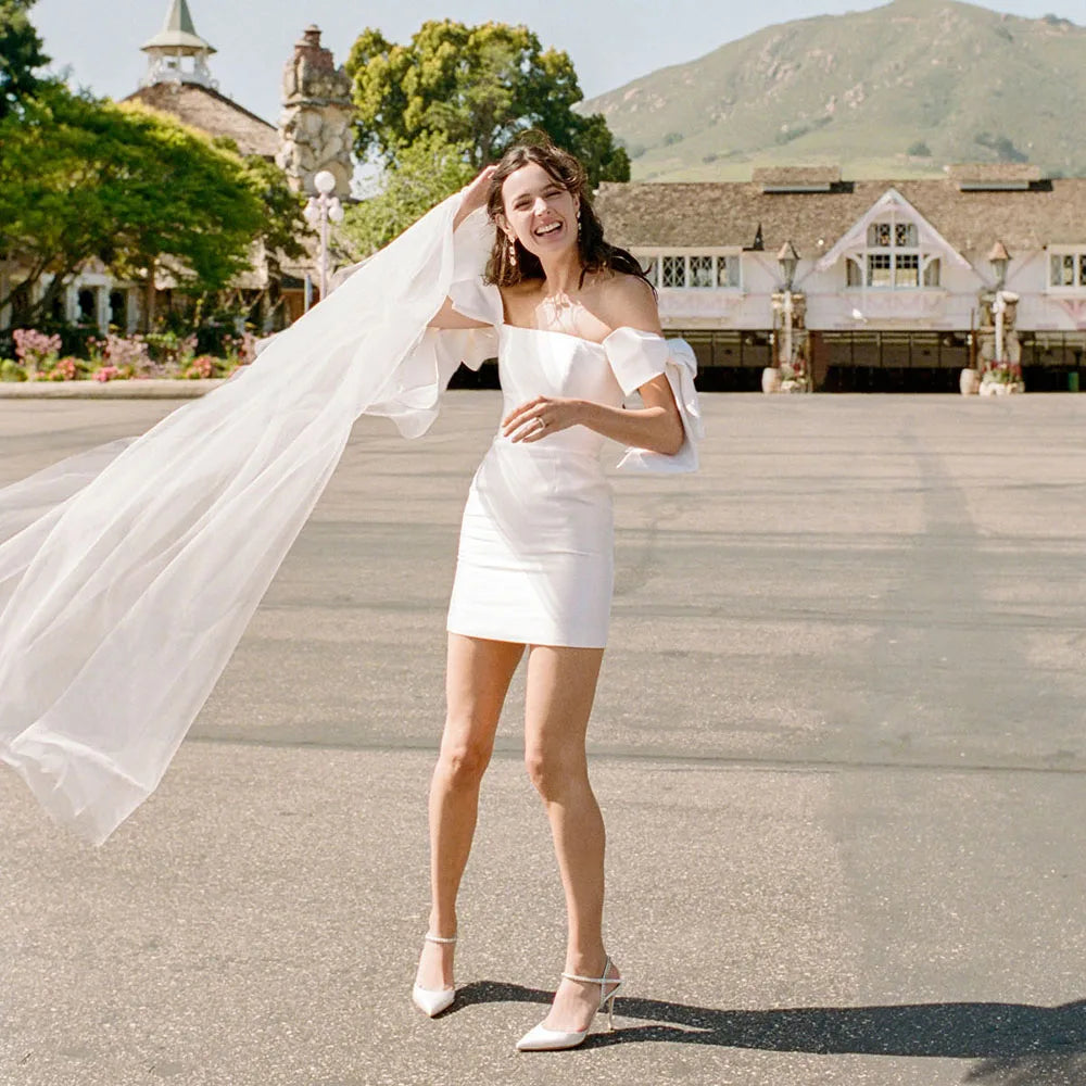Look dreamy in this Mini Bridal Robe Lisette! Featuring a simple satin sheath fit with bow and custom-made elastic straps, you'll be the glamourous star of the show on your special day. Slip into this above-knee beauty and feel like the queen you are!