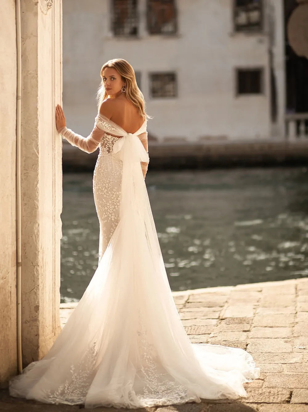 Elevate your bridal look with the exquisite Robe Viviette. This elegant bohemian gown features off-the-shoulder long sleeves, adding a touch of romance to your special day. The vintage design and intricate detailing make it the perfect choice for the stylish and sophisticated bride. Make a statement with Robe Viviette.