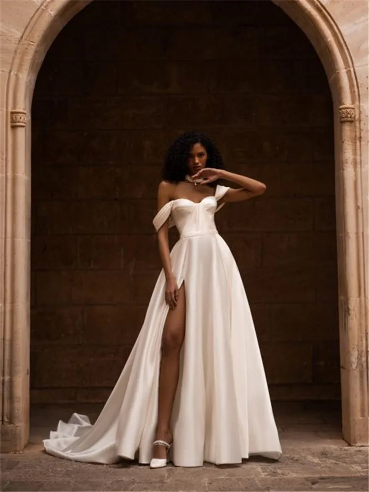 Indulge in luxury with our Robe Ivette. Made from smooth satin, this off-shoulder wedding dress exudes elegance and charm. Its simple design and lightweight material make it perfect for a beach wedding. Complete your bridal look with our exclusive Robe Ivette and feel like a true bride on your special day.