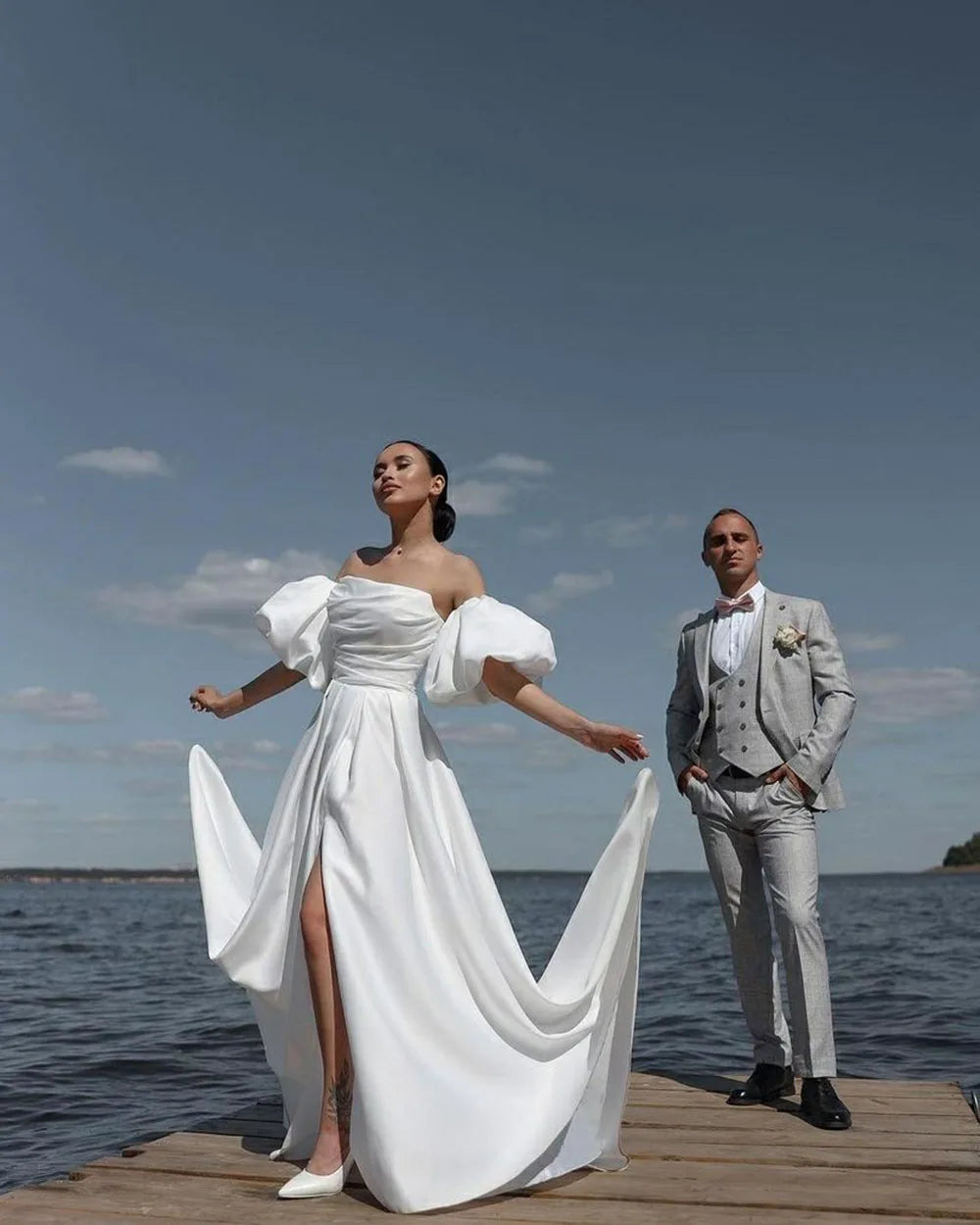 The Robe Sacha is the perfect choice for any beach or destination wedding. Its off-the-shoulder design and short sleeves add a touch of elegance, while the side split adds a sexy and modern twist. Made of high-quality satin, this dress is both stylish and comfortable, making it the ideal choice for any bride.