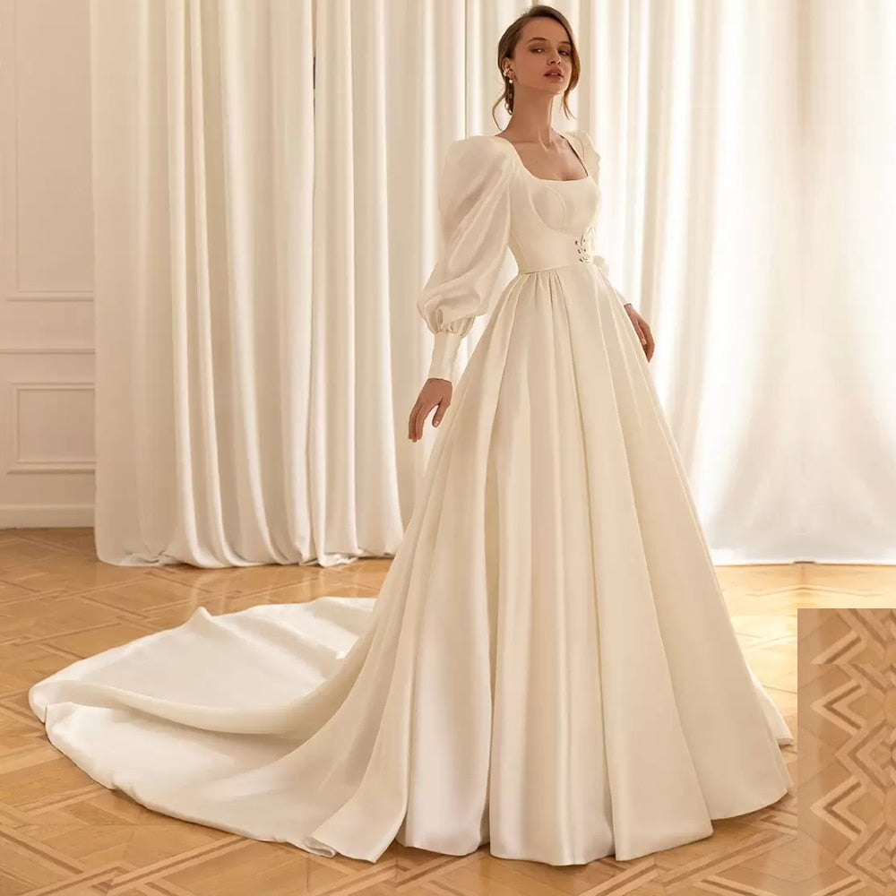 Feel like a princess on your special day with our Robe Sancia. The square neckline and full, long sleeve puff design adds elegance to the A-line silhouette. This two-piece bridal gown is perfect for any bride, ensuring a stunning and timeless look