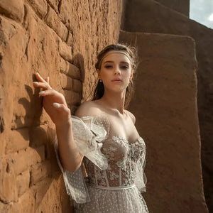 Indulge in the exquisite elegance of our Bohemian A Line Wedding Dress - Dress Violet. The beautiful off shoulder design and the fluffy sleeves will make you feel like a romantic goddess, while the elegant lace applique and backless style add a touch of sensuality. Say "I do" in style with this eye-catching dress that will make you feel confident and stunning on your special day.